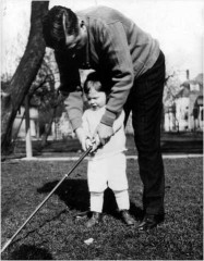 Gerry as a child, holding a golf club with his father, circa 1929-1930